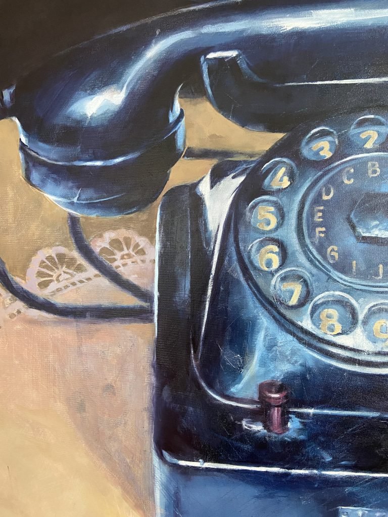 Glossy black surface of rotary telephone reflecting blue light