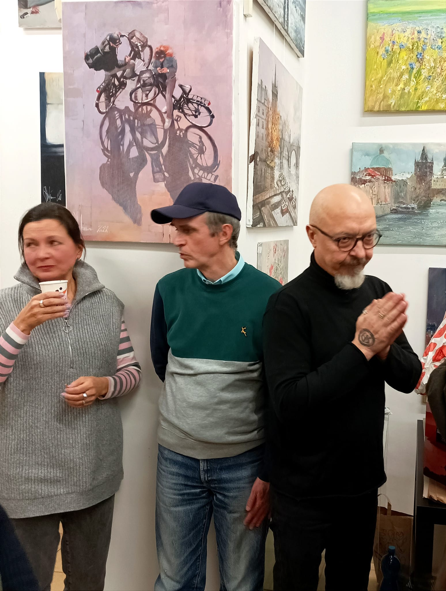 Igor Shulman with visitors at ART Gallery 11 Prague, "Meeting after Work" painting visible in the background