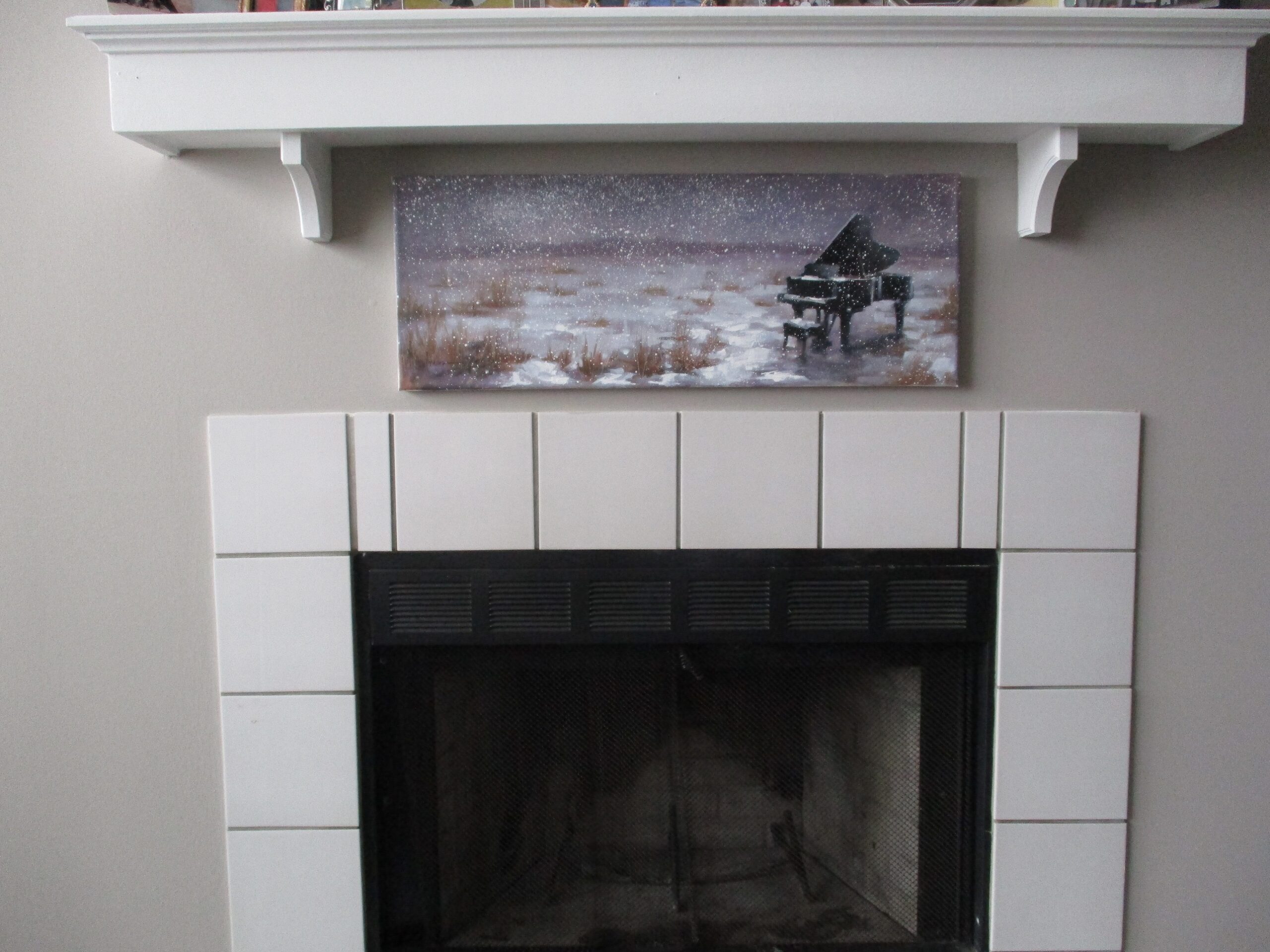 The finished winter piano painting hanging in a niche above a fireplace in Connie's home.