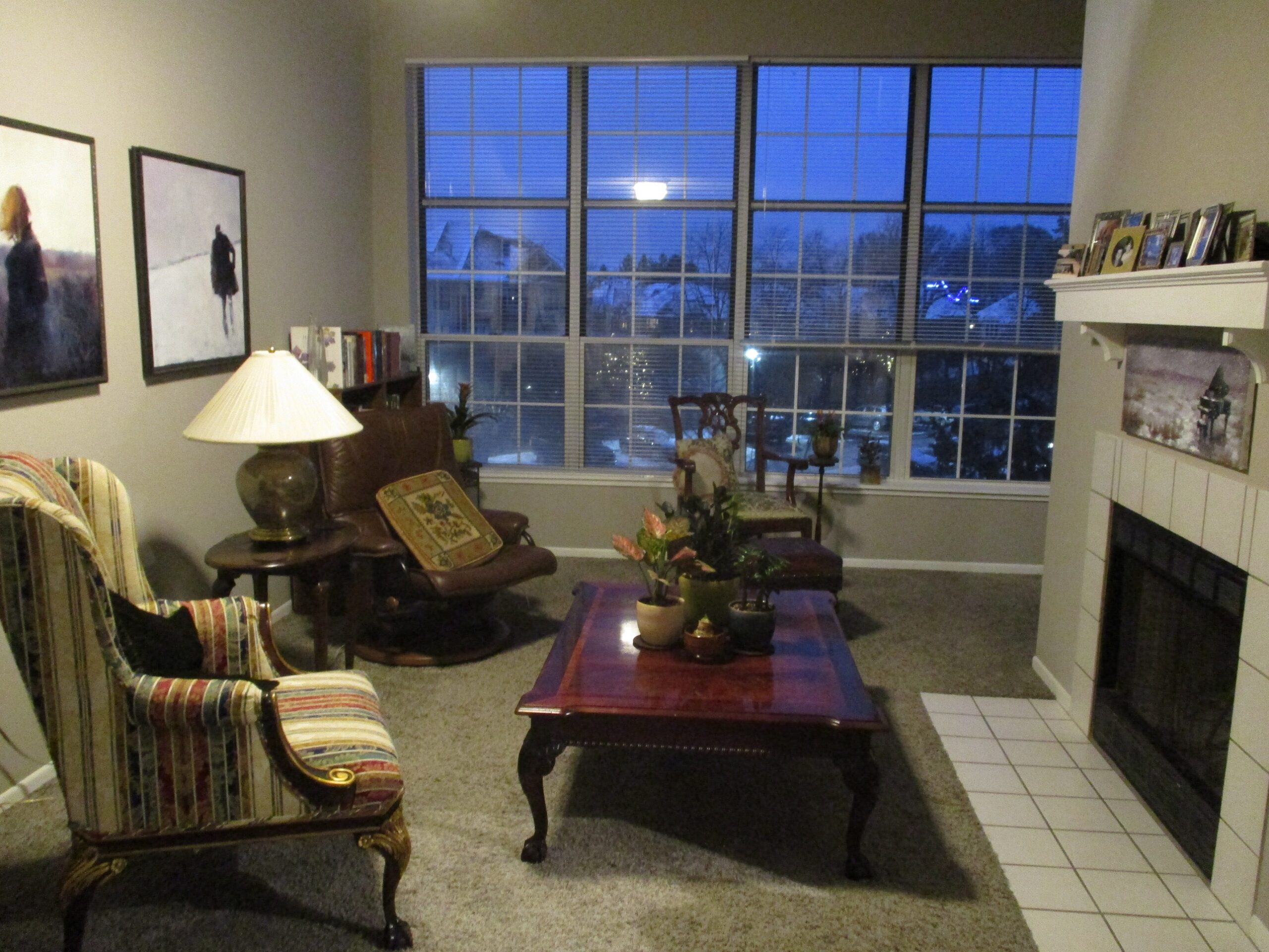 The winter piano painting displayed on a wall in Connie's home alongside other paintings by Igor Shulman across from the fireplace.